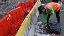 Petugas PPSU membersihkan sampah sisa perayaan Hari Buruh Internasional di kawasan Silang Barat Daya Monas, Jakarta, Rabu (1/5). Sampah yang berserakan di kawasan tersebut membuat Petugas PPSU bekerja ekstra keras untuk membersihkan kawasan tersebut. (Liputan6.com/Helmi Fithriansyah)