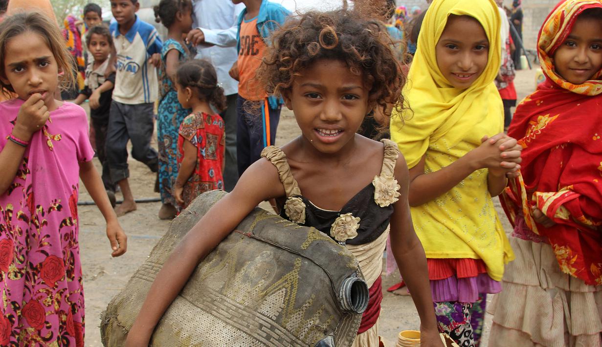 Seorang anak wanita membawa jerigen untuk mengisi air untuk mengisi air bersih di desa Hodeidah, Yaman (17/4). (AFP PHOTO / Stringer)