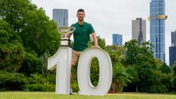 Petenis Serbia Novak Djokovic berpose dengan Norman Brookes Challenge Cup usai menjuarai Australian Open 2023 di Taman Government House, Melbourne, Australia, 30 Januari 2023. Ini adalah gelar Australian Open ke-10 untuk Djokovic. (AP Photo/Ng Han Guan)