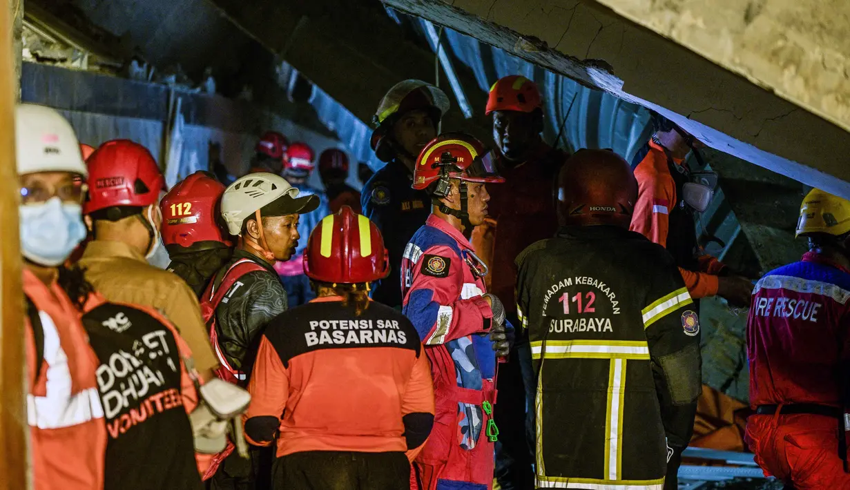 Petugas gabungan dari unsur SAR, TNI, dan Polri terus berupaya untuk melakukan evakuasi sejumlah santri yang masih terjebak di bawah reruntuhan bangunan. (Juni Kriswanto/AFP)