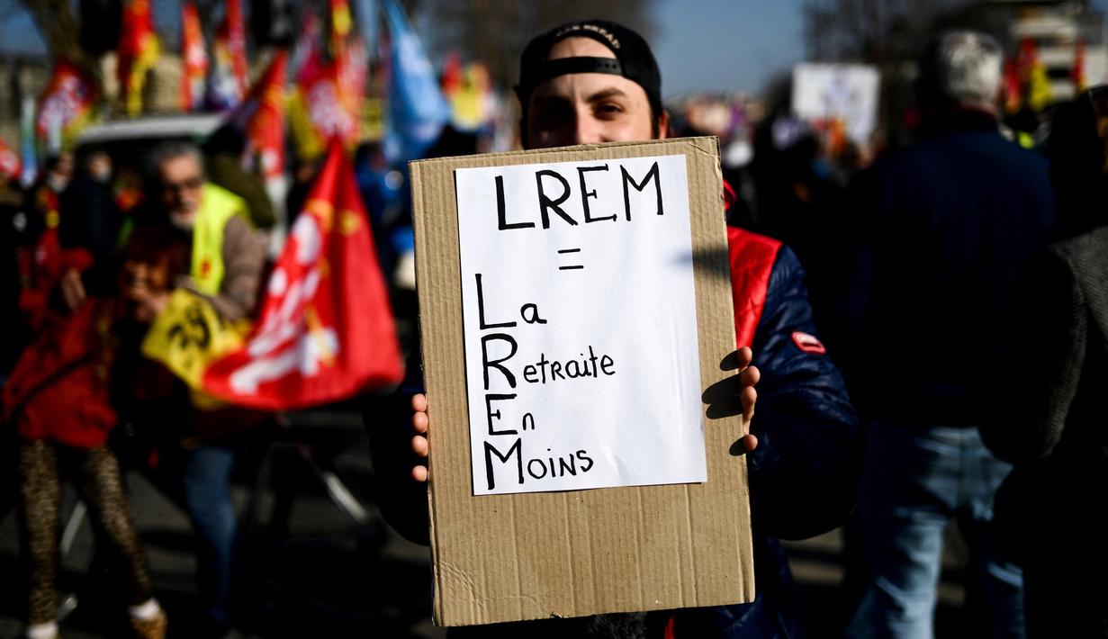 Seorang pengunjuk rasa memegang tanda bertuliskan "LREM: kurangi uang pensiun" selama demonstrasi pada hari kelima demonstrasi nasional yang diselenggarakan sejak awal tahun, menentang perombakan pensiun yang sangat tidak populer, di Avignon, Prancis Selatan, Kamis (16/2/2023). (CHRISTOPHE SIMON/AFP)