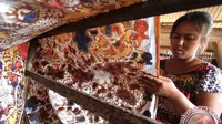 Perajin batik buat motif bertemakan cerita anak guna memperkenalkan batik kepada anak-anak.
