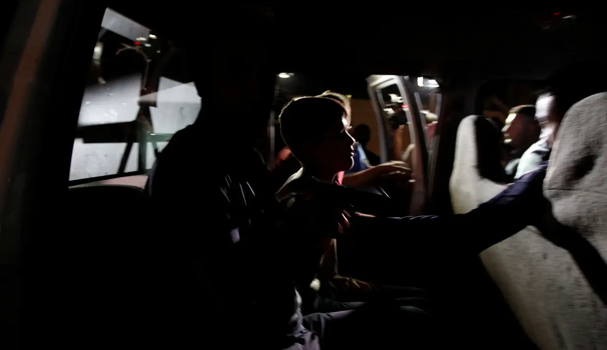 Pasukan keamanan Irak membawa seorang bocah yang membawa bom ke dalam mobil di Kirkuk, Irak, (21/8). Bocah ini dicurigai dijadikan pengebom bom bunuh diri anak oleh militan ISIS. (REUTERS/Ako Rasheed)