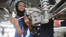 Montir perempuan Pakistan Uzma Nawaz (24) memperbaiki mobil di sebuah bengkel kota Multan, 1 September 2018. Sejak menjadi montir perempuan pertama di Pakistan yang konservatif, Uzma kerap menghadapi dua reaksi umum, terkejut dan syok. (S.S. Mirza/AFP)
