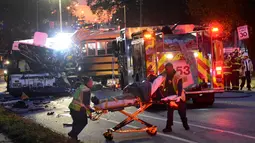 Petugas medis mengevakuasi korban tabrakan antara bus komuter dengan bus sekolah di Baltimore, Maryland, Selasa (1/11). Bus sekolah tanpa penumpang itu menabrak bagian depan bus komuter. (Courtesy Jeffrey F. Bill/Baltimore Sun via REUTERS)