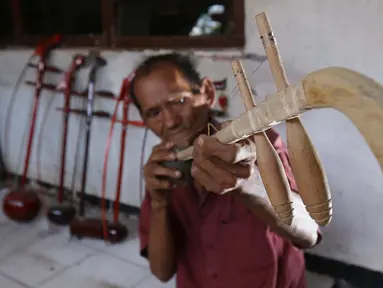 Ghohyong mengecek alat musik Tehyan buatannya di Neglasari, Kota Tangerang (5/2/2021). Ghohyong merupakan pria tua yang ahli membuat dan mahir memainkan alat musik Tehyan khas Tionghoa. (Liputan6.com/Angga Yuniar)
