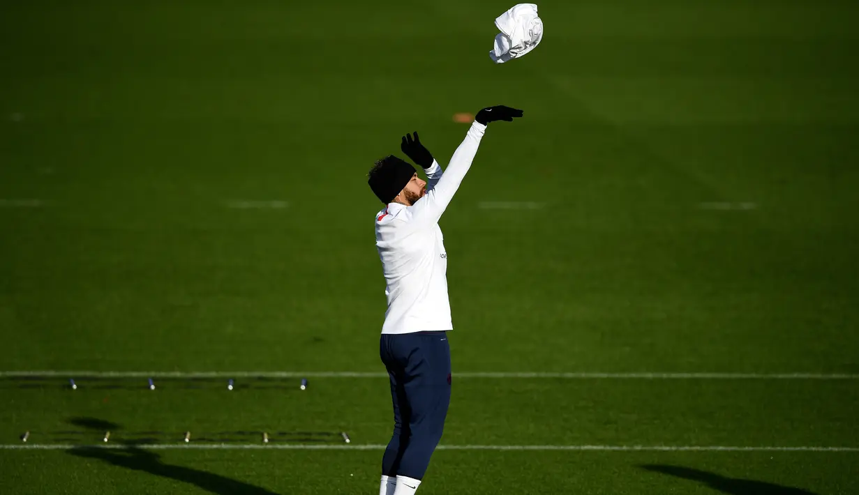 Penyerang Paris Saint-Germain (PSG), Neymar melempar kaos saat mengikuti sesi latihan tim di Saint-Germain-en-Laye (10/12/2019). PSG akan bertanding melawan wakil Turki, Galatasaray pada Grup A Liga Champions di Parc des Princes. (AFP/Franck Fife)