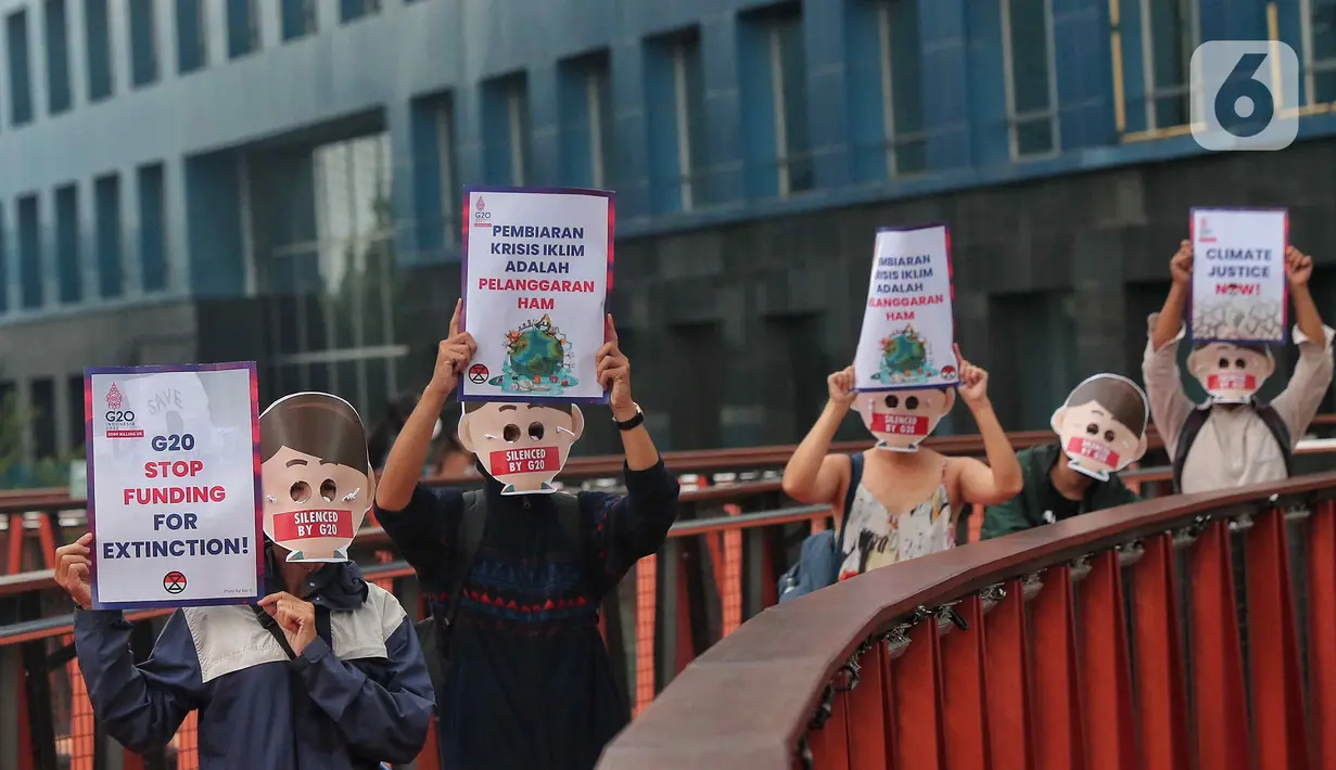 Sejumlah aktivis yang tergabung dalam Extintion Rebellion (XR) dan Walhi Jakarta melakukan aksi di JPO Pinisi, Jalan Jenderal Sudirman, Jakarta, Senin (14/11/2022). Aksi tersebut dilakukan untuk menyerukan kepada para pemimpin agar menghentikan “pencucian hijau” dan praktik ekonomi “business-as-usual” yang secara sistematis memperburuk krisis iklim dan mendorong umat manusia pada kehancuran ekologis & kepunahan massal. Negara-negara G20 turut menyumbang atas 80 persen emisi karbon dunia dan 60 persen populasi penduduk bumi. (Liputan6.com/Angga Yuniar)