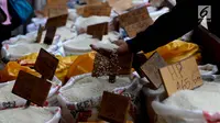 Pedagang melihat beras dagangannya di Pasar Induk Cipinang, Jakarta, Senin (25/9). Pedagang beras Cipinang sudah menerapkan dan menyediakan beras medium dan beras premium sesuai harga eceran tertinggi (HET). (Liputan6.com/Angga Yuniar)