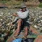 Warga menggunakan perahu untuk memilah sampah plastik di aliran Sungai Citarum, Bandung, Rabu (26/6/2019). Menurut warga di kawasan itu volume sampah kiriman yang kerap menumpuk mulai mengalami penurunan setelah beberapa waktu lalu sempat menutupi permukaan aliran Sungai Citarum (Timur Matahari/AFP)