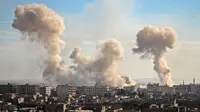 Asap membumbung tinggi setelah pasukan pemerintah membombardir wilayah Ghouta Timur, Damaskus, Suriah, Senin (19/2). Hampir 400 ribu orang tinggal di Ghouta Timur, wilayah di Suriah yang telah dikepung sejak 2013. (AFP PHOTO/Hamza Al-Ajweh)