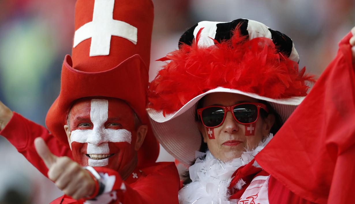 Sepasang suporter Swiss saat mendukung negaranya melawan Serbia pada laga grup E Piala Dunia di Stadion Kaliningrad, Kaliningrad, Jumat (22/6/2018). Cerita sepenggal kisah romantis saat Piala Dunia 2018 Rusia. (AP/Antonio Calanni)