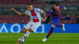 Pemain Barcelona Gerard Pique (kanan) mencoba menghentikan pemain Paris Saint-Germain Kylian Mbappe pada leg pertama babak 16 besar Liga Champions di Camp Nou, Barcelona, Spanyol, Selasa (16/2/2021). PSG menang 4-1. (AP Photo/Joan Monfort)