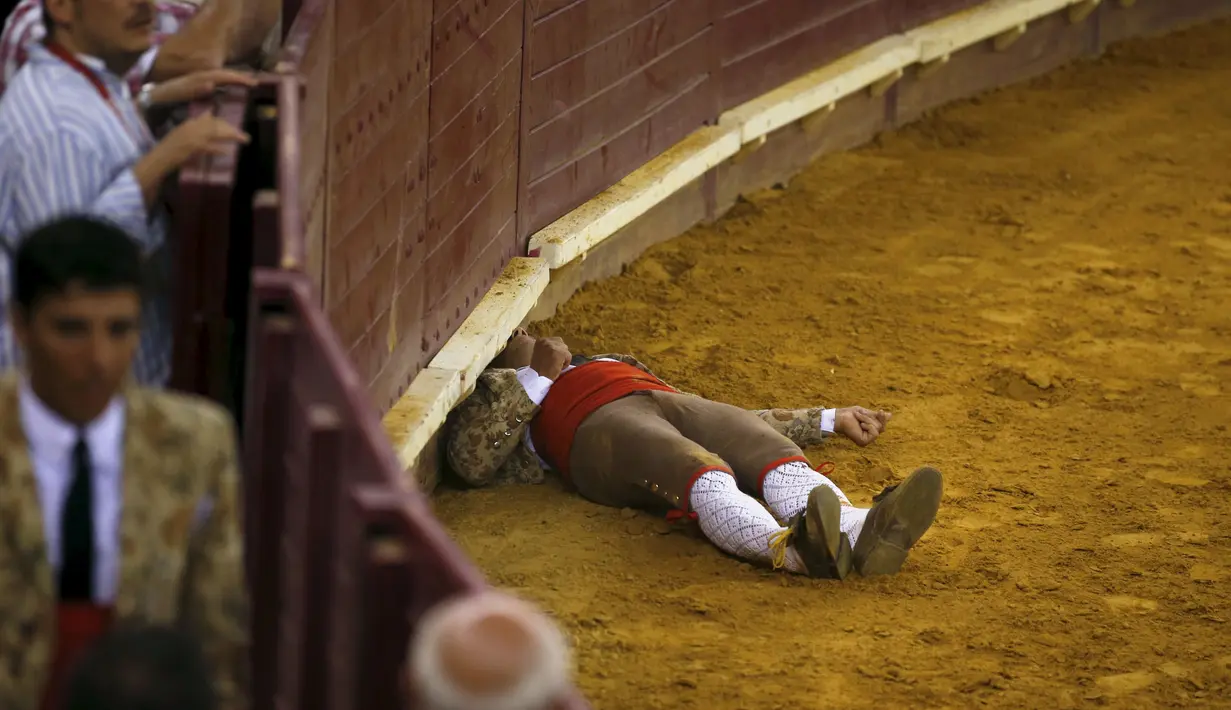 Seorang anggota Ribatejo Forcados tergeletak,  setelah ia dilemparkan oleh seekor banteng di arena Campo Pequeno, Lisbon, Portugal, Kamis (9/7/2015). Perlu keahlian khusus untuk memainkan olahraga ini.( REUTERS/Rafael Marchante)