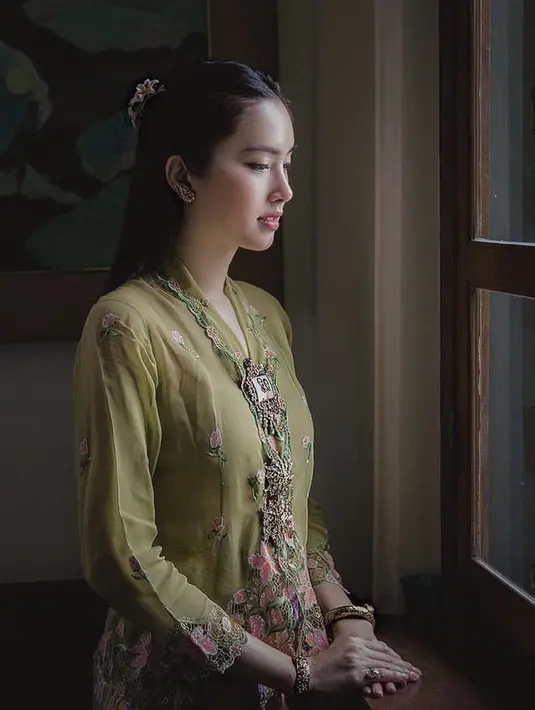 Nampak ia pun memesona dengan kebaya model encim warna hijau yang memiliki detail bordiran bunga.Credit: @poydtreechada.