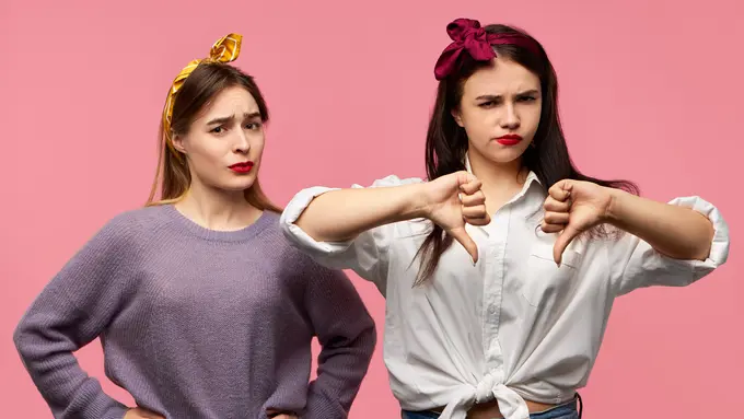 Dua orang perempuan mengerutkan keningnya dengan salah seorang mengacungkan jempol ke bawah (Foto Dok: Freepik/karlyukav)