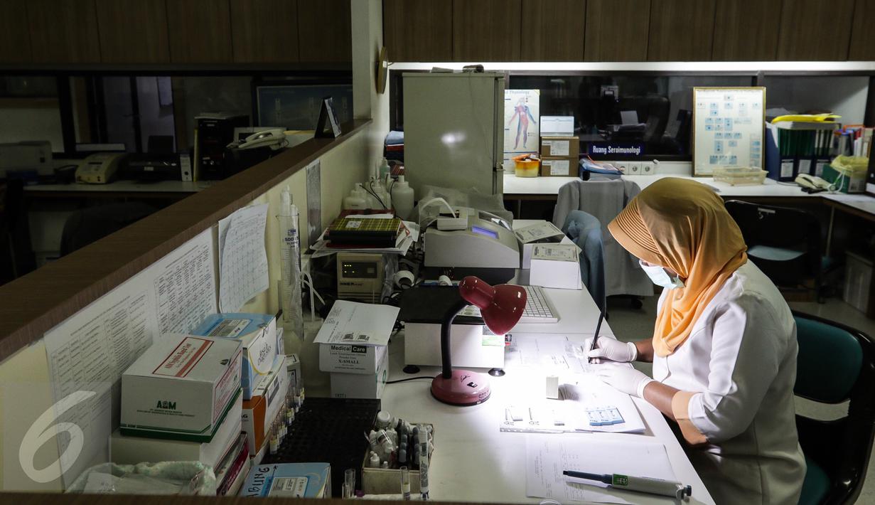 Seorang teknisi kesehatan menulis hasil pemeriksaan di ruang sero imunologi laboratorium kesehatan Rumah Sakit Husada, Jakarta, Rabu (08/2). (Fery Pradolo/Liputan6.com)