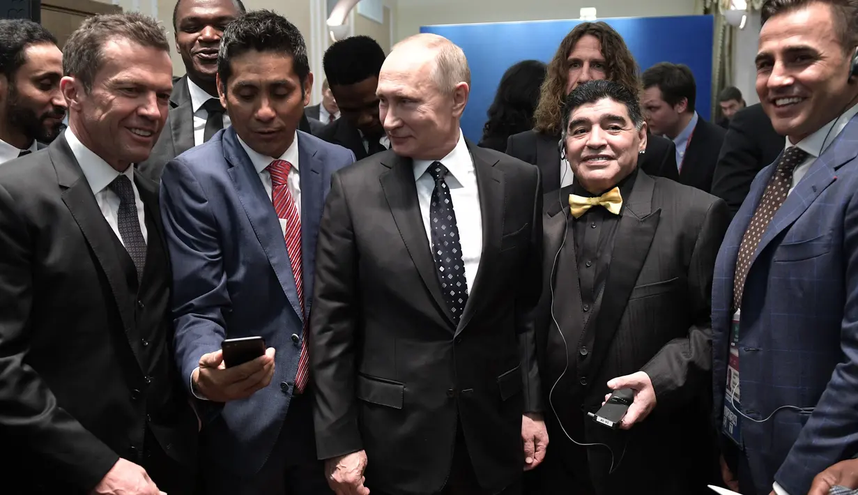 Presiden Rusia Vladimir Putin (tengah) berfoto bersama dengan Diego Maradona (kedua kanan) saat menghadiri undian Piala Dunia 2018 di Moskow, Rusia (1/12). (AFP Photo/Sputnik/Alexey Nikolsky)