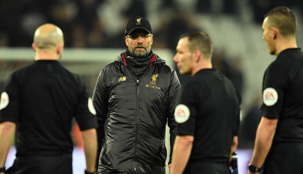 Pelatih Liverpool, Jurgen Klopp berjalan menghampiri para wasit usai pertandingan melawan West Ham United pada lanjutan Liga Inggris di The London Stadium (4/2). Liverpool bermain imbang 1-1 atas West Ham. (AFP Photo/Glyn Kirk)