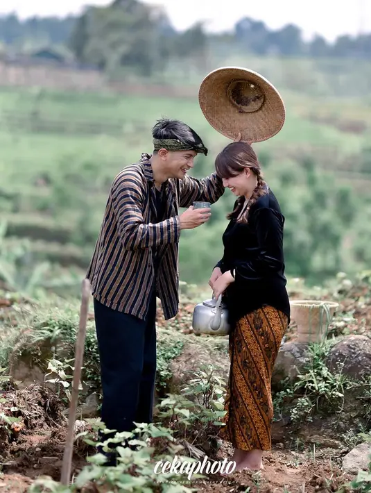 Sebagai pelengkap, sesi pemotretan ini juga menggunakan properti yang sama persis dengan peralatan yang dibawa petani. Reiner membawa cangkul dan pakai topi bambu untuk melindunginya dari sinar matahari. Sementara, Adisty tampak membawa cerek dan wakul dari anyaman bambu. (Liputan6.com/IG/@adistyjuniar)