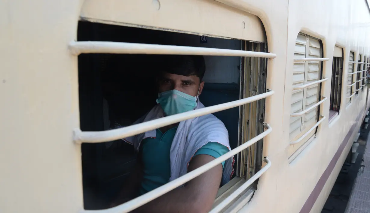 Seorang buruh migran memandang dari balik jendela ketika menaiki kereta khusus menuju rumahnya saat masa karantina wilayah (lockdown) nasional diterapkan demi mencegah penyebaran COVID-19 di Jalandhar, Negara Bagian Punjab, India utara, (5//5/2020). (Xinhua/Stringer)