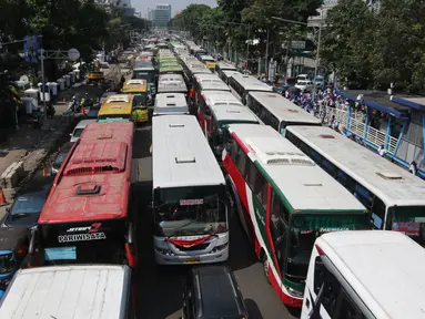 Puluhan bus yang mengangkut buruh memadati Jalan Medan Merdeka Timur, Jakarta, Selasa (1/5). Berdasarkan data kepolisian, sekitar 30 ribu buruh melakukan aksi May Day 2018 di Jakarta. (Liputan6.com/Arya Manggala)