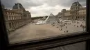 Piramida Louvre yang berada di taman Museum Louvre terlihat dari sebuah kaca jendela di Paris, 16 Mei 2016. (LIONEL Bonaventure/AFP)