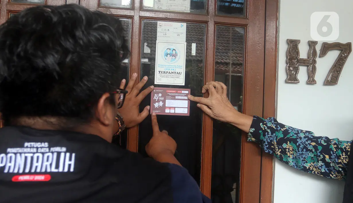 Petugas Pemutakhiran Data Pemilih (Pantarlih) menempelkan stiker pada jendela rumah warga saat melakukan pencocokan dan penelitian (coklit) data pemilih untuk Pemilu 2024 di rumah warga di Beki, Depok, Jawa Barat, Minggu  (26/2/2023). Komisi Pemilihan Umum (KPU) di semua wilayah Indonesia melakukan pencocokan dan penelitian (coklit) data pemilih dengan datang dari rumah ke rumah guna mengantisipasi ketidaksesuaian data Pemilu 2024. (merdeka.com/Arie Basuki)