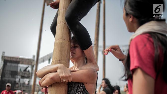 Seorang wanita warga negara asing saat mengikuti panjat pinang kolosal saat HUT ke-74 RI di Pantai Karnaval Ancol, Jakarta, Senin (17/8/2019). Sebanyak 174 batang pinang dengan beragam hadiah disediakan dalam lomba yang diikuti ratusan warga itu. (Liputan6.com/Faizal Fanani)