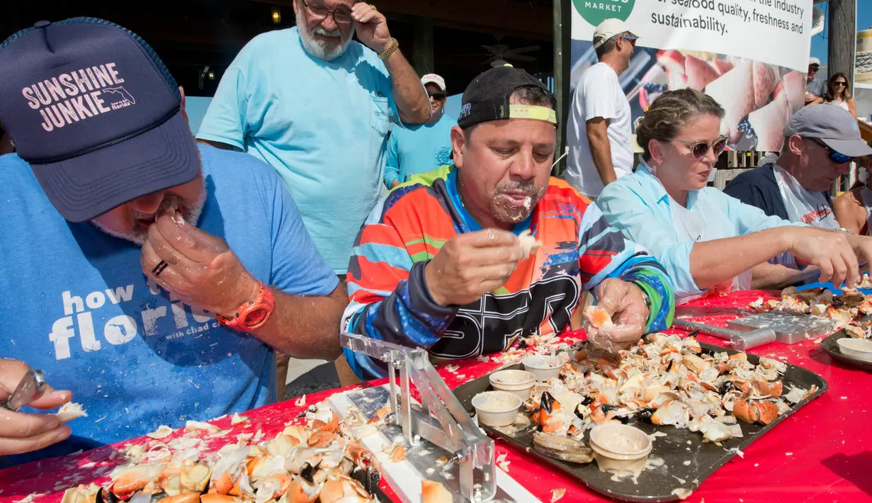 Para peserta beradu cepat memakan daging kepiting batu dalam kontes Key Fisheries Stone Crab Eating di Marathon, Florida, Sabtu (10/11). Mereka harus memecahkan cangkang 25 kepiting batu lalu memakan dagingnya. (Andy Newman/Florida Keys News Bureau/AFP)