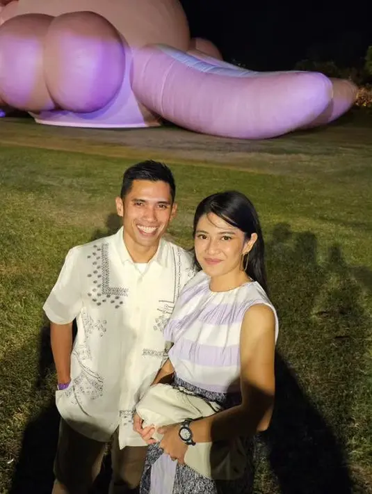Tampil senada dengan pasangan seperti Dian Sastrowardoyo mengenakan sleeveless warna putih keunguan dipadukan bawahan kain. Sedangkan suaminya mengenakan kemeja putih. [@therealdisastr]
