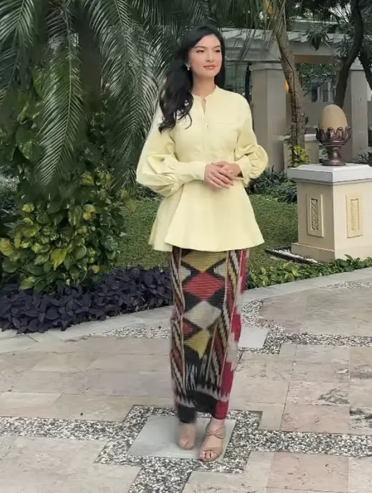 Busana tersebut dipadukan dengan heels coklat motif strap pita dua bagian. Serta aksesori anting-antingnya. (@ralineshah)