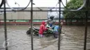 Penyedia jasa gerobak mengangkut warga menerobos banjir yang merendam Jalan Gunung Sahari, Jakarta Pusat, Selasa (21/2). Hujan deras yang mengguyur sejak Selasa dini hari membuat sebagian wilayah di Jakarta banjir. (Liputan6.com/Faizal Fanani)