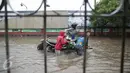Penyedia jasa gerobak mengangkut warga menerobos banjir yang merendam Jalan Gunung Sahari, Jakarta Pusat, Selasa (21/2). Hujan deras yang mengguyur sejak Selasa dini hari membuat sebagian wilayah di Jakarta banjir. (Liputan6.com/Faizal Fanani)