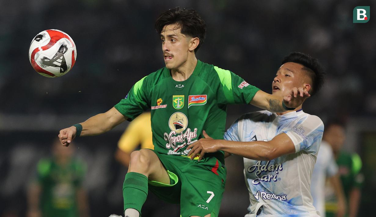 Pemain Persebaya Surabaya, Rivera (kiri) mencoba mengamankan bola dari pemain PSIM Yogyakarta pada pertandingan pembuka BRI Super League 2025/2026 di Stadion Gelora Bung Tomo, Jumat (08/08/2025) malam WIB. (Bola.com/Abdul Aziz)