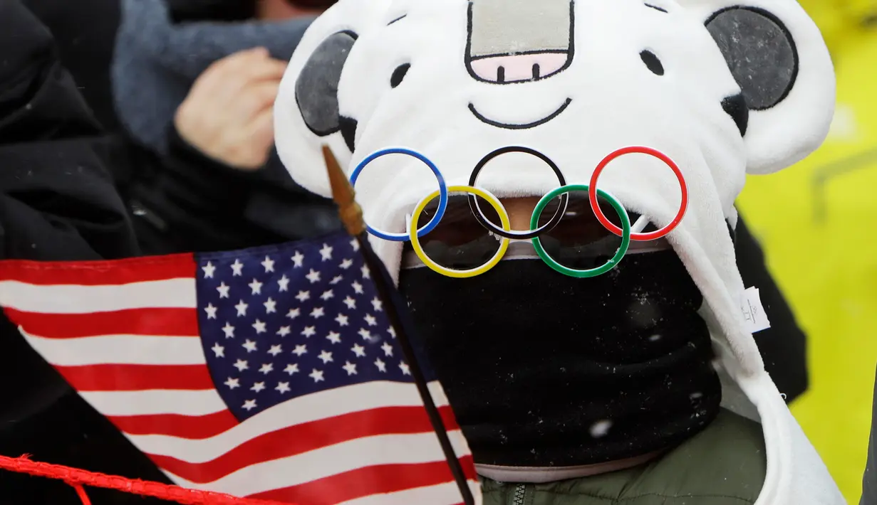 Seorang anak mengenakan kacamata unik saat menyaksikan pertandingan nomor giant slalom putri pada Olimpiade Musim Dingin 2018 di PyeongChang, Korea Selatan, Rabu (14/2). Ada 92 negara peserta yang mengikuti ajang tersebut. (AP/Michael Probst)
