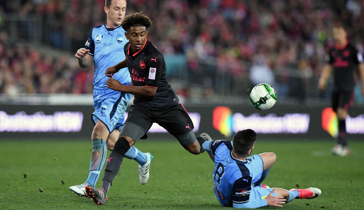 Gelandang Arsenal, Reiss Nelson, berusaha melewati gelandang Sydney FC, Paulo Retre, pada laga persahabatan di Stadion ANZ, Sydney, Kamis (13/7/2017). Arsenal menang 2-0 atas Sydney FC. (EPA/Paul Miller)