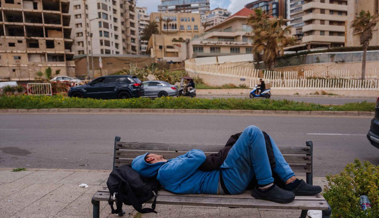 Intensitas serangan Israel menargetkan sejumlah wilayah di Lebanon, termasuk ibu kota Beirut dan wilayah perbatasan. Tampak dalam foto, seorang pria pengungsi tidur di bangku jalanan di Beirut pada 30 Maret 2026. Israel memperbarui pemboman pinggiran selatan Beirut, Lebanon, pada Senin 30 Maret 2026. (Dimitar DILKOFF/AFP)