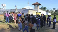 Para warga dan keluarga menunggu dengan khawatir di luar penjara ketika terjadi perang antar geng yang menewaskan 57 orang (AP/Wilson Soares)