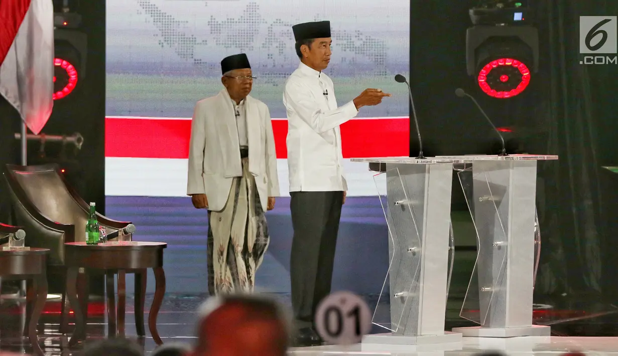 Capres nomor urut 01 Joko Widodo dan Cawapres Ma'ruf Amin bersiap menyampaikan visi dan misi selama Debat Pilpres 2019 kelima, Jakarta, Sabtu (13/4). Debat kelima merupakan debat terakhir dalam masa kampanye dan mengambil tema Ekonomi, Kesejahteraan Sosial, Keuangan dan Investasi. (Liputan6.com/Joha