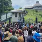 Warga Kepulauan Solomon berkumpul di depan gedung Parlemen di Honiara, menuntut pengunduran diri Perdana Menteri Manasseh Sogavare.(ABC News: Evan Wasuka)