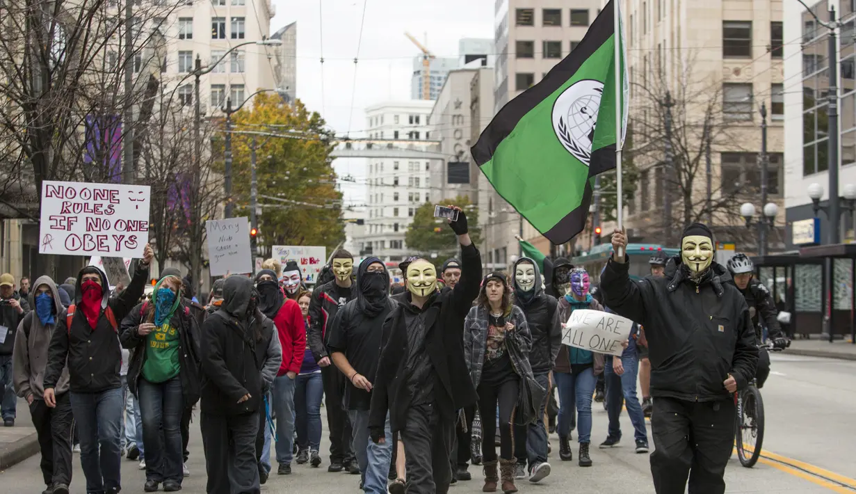 Demonstran mengenakan topeng Guy Fawkes saat menggelar aksi "Sejuta Topeng" di Washington, Amerika Serikat, Kamis(5/11/2015).  Para Demonstran memblokir lalu lintas disekitar Gedung Pengadilan federal dan kampus Amazon. (REUTERS/Jason Redmond)