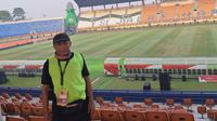 Petugas kebersihan Stadion Si Jalak Harupat, Arifin, berbagi cerita dengan Bola.com mengenai makna Piala Presiden 2025. (Bola.com/Muhammad Adi Yaksa)