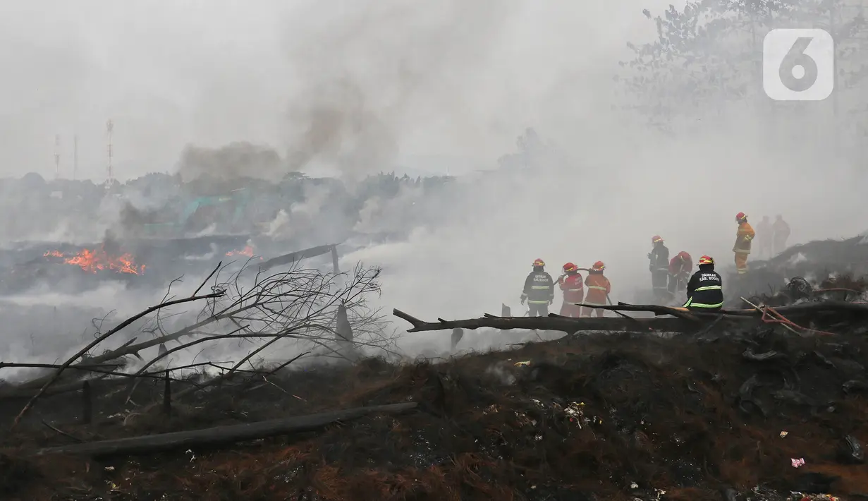Petugas Pemadam Kebakaran Kabupaten Bogor memadamkan api di lapak ban bekas, Desa Bojong Nangka, Gunung Putri, Kamis (22/4/2021). Banyaknya bahan yang mudah terbakar dan sumber api yang berasal dari bawah tumpukan ban membuat  api di lokasi belum juga padam. (Liputan6.com/Herman Zakharia)