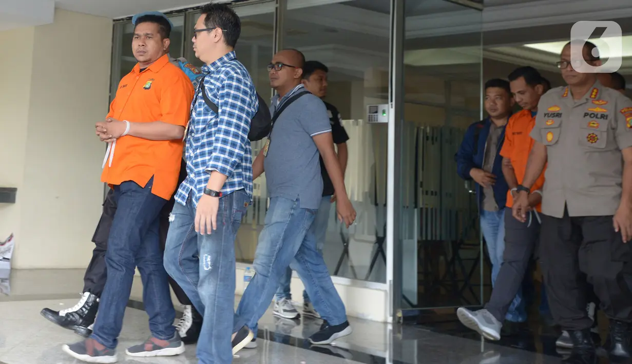 Polisi mengawal dua tersangka kasus penyiramanan air keras terhadap penyidik senior KPK Novel Baswedan di Polda Metro Jaya, Jakarta, Sabtu (28/12/2019). Tersangka berinisial RM dan RB dipindahkan dari Polda Metro Jaya ke Bareskrim Mabes Polri untuk penyidikan lebih lanjut. (merdeka.com/Imam Buhori)