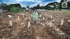 Seorang petugas berjalan di antara makam jenazah dengan protokol COVID-19 di TPU Srengseng Sawah 2, Jakarta, Selasa (9/2/2021). TPU Srengseng Sawah 2 yang sudah lebih dari sepekan dibuka untuk pemakaman dengan protokol COVID-19 ini mampu menampung seribu lebih liang lahat. (merdeka.com/Arie Basuki)