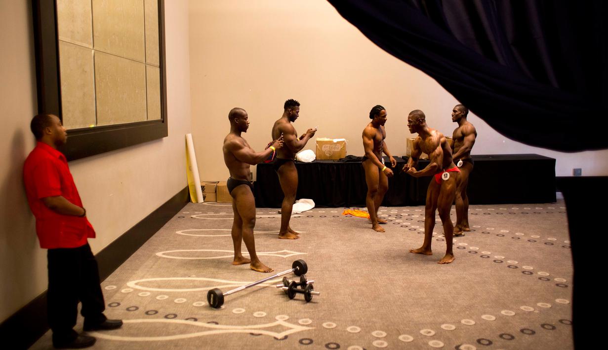 Para binaragawan asal Haiti berfoto ria sebelum berkompetisi di Port-au-Prince, Haiti, Minggu (23/7). Haiti memiliki banyak bibit unggul untuk menjadi juara kelas dunia di bidang olahraga binaraga. (AP/Dieu Nalio Chery)