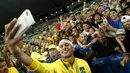 Bintang sepak bola Brasil, Neymar, berfoto bersama pendukungnya setelah meraih emas sepak bola Olimpiade Rio 2016 setelah mengalahkan Jerman di final, (20/8/2016). (AFP/Odd Andersen)