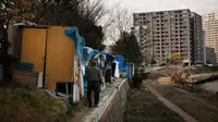 Seorang tunawisma berjalan ke gubuknya di sebuah kamp tunawisma sepanjang Sungai Tama, Kawasaki, Jepang, Selasa (14/1/2020). Seperti Amerika Serikat, Jepang memiliki tingkat kemiskinan yang relatif tinggi untuk negara kaya. (AP Photo/Jae C. Hong)