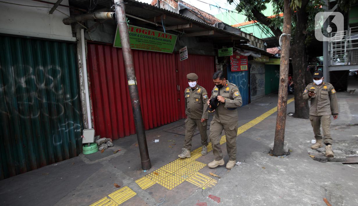 Petugas Satpop PP berpatroli di kawasan Pasar Tanah Abang, Jakarta, Rabu (7/7/2021). Satpol PP melakukan penjagaan di seluruh Pasar Tanah Abang mengantisipasi pedagang yang membandel tetap berjualan saat diberlakukannya PPKM Darurat. (Liputan6.com/Angga Yuniar)